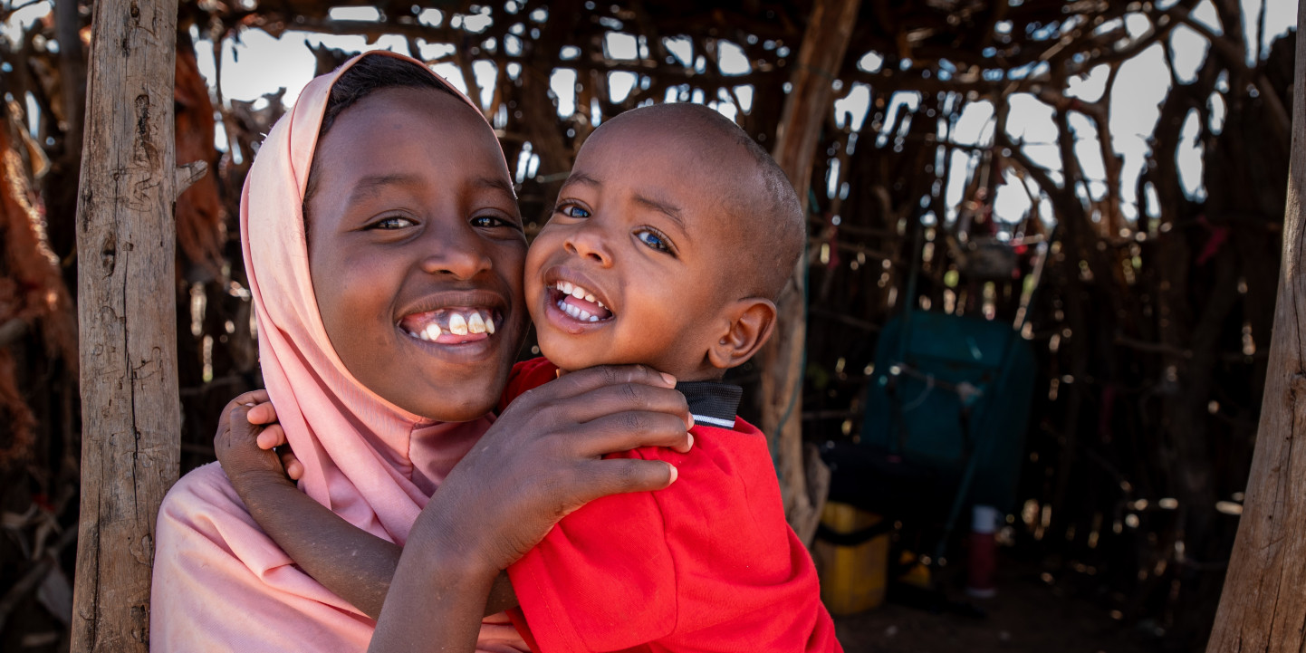 CH11157147 Close up of Faduma, 10 as she holds and cuddles her little brother Abdi, year and a half, Somaliland