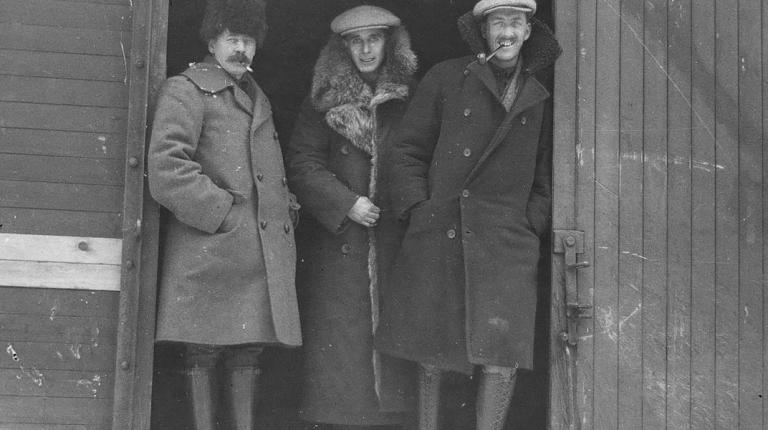 three men standing in train