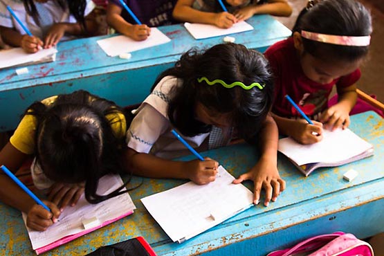 Children writing in a classroom